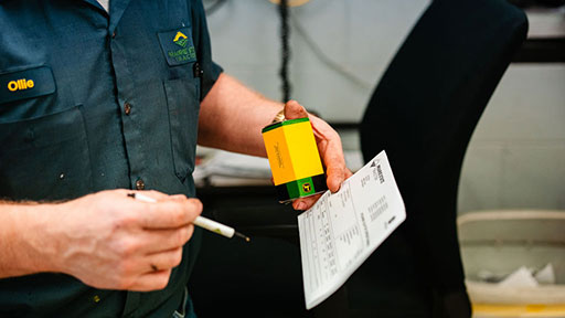 parts sales consultant holding a John Deere part and invoice